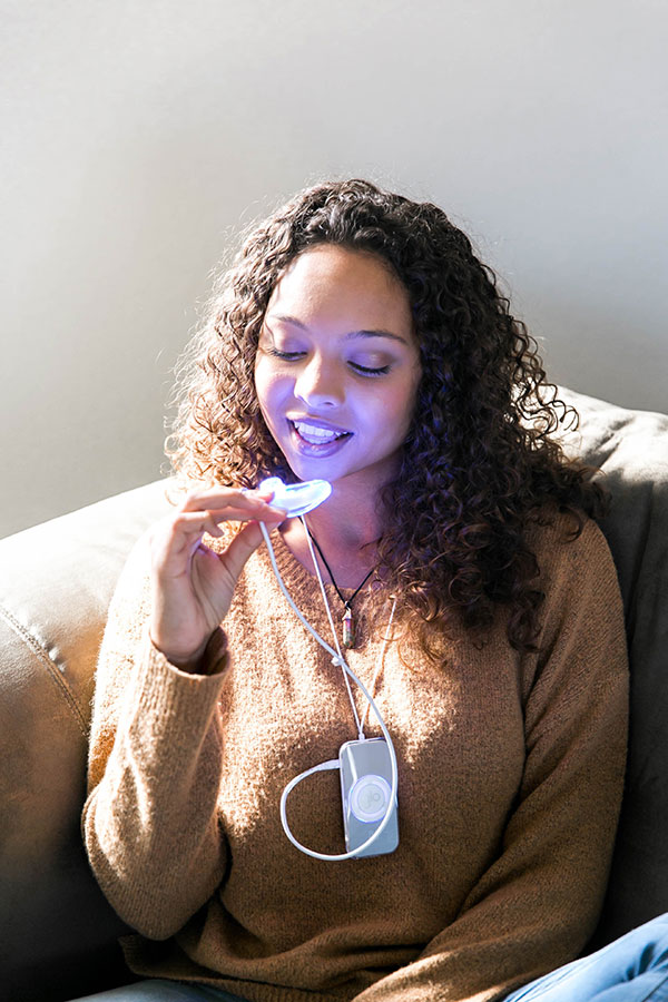 Woman Whitening Teeth Using GLO